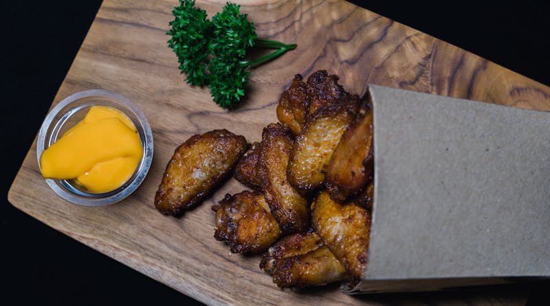 Crispy Chicken Wings with ranch dipping sauce tossed in Buffalo sauce